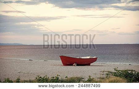 Boat On The Beach. Fishermens Boat At Seacoast, On Sand On Cloudy Day With Sea On Background. Travel