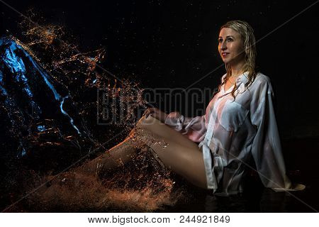 Nice Girl In The White Shirt And Water Drops Behind And Arround Her Illuminated By Light During A Ph