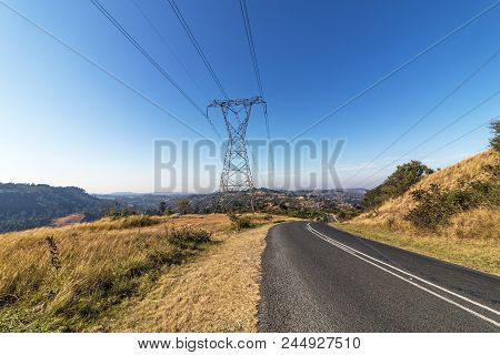 Overhead Pylon And Powerlines Next To Asphalt Road