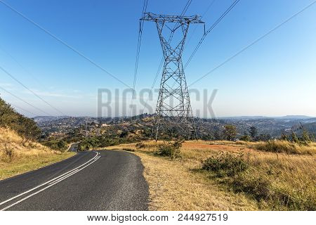 Overhead Pylon And Powerlines Next To Asphalt Road
