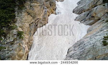 Aerial View Of The Mudflow With Snow High In The Alpine Mountains.
