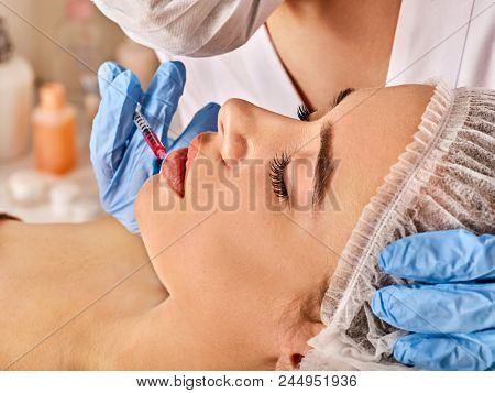 Filler injection for female forehead face. Plastic aesthetic facial surgery in beauty clinic. Beauty woman giving injections. Doctor with syringe injects lips augmentation.