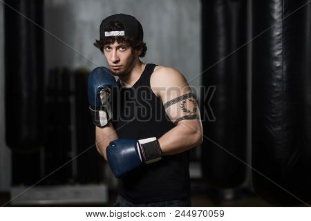 Muscular Young Boxer Training With Punching Bag