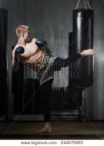 A Young Boxer Has His Foot On The Punching Bag