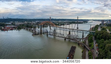 Aerial Panoramic View Of Pattullo And Skytrain Bridge Going Across Fraser River Duing A Cloudy Eveni