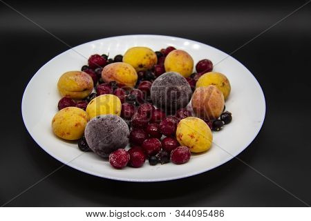 A Berry Mix From Frozen Currant, Apricot, Plum, Cherry On The White Plate. Frozen Berries From Freez