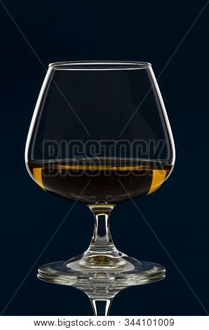 Glass Of Calvados Brandy And Red Apples With Reflection