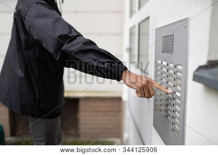 Man Standing At The Entrance Of The House Ringing The Door Bell