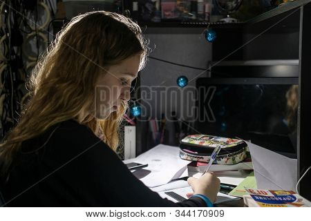 image of a girl doing school homework in the evening