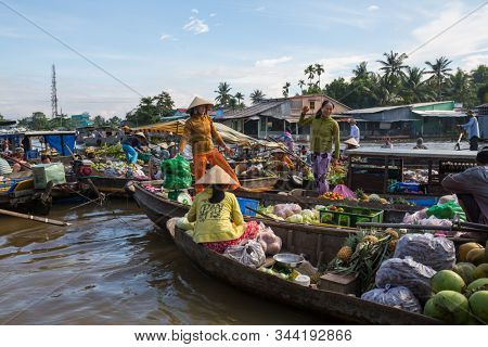 MEKONG DELTA, VIETNAM - CIRCA NOVEMBER 2019: Vietnamese farmers sell goods on a daily floating market circa November 2019 in delta of Mekong. Markets in Mekong delta are popular tourists destination.