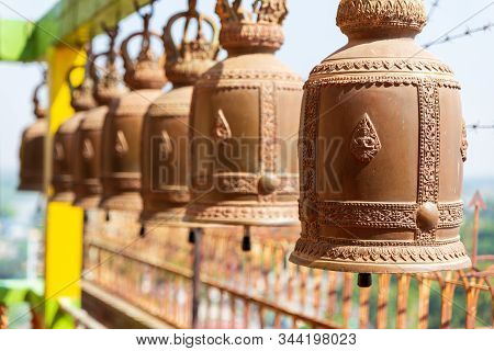 Brass Bells Hanging On Steel Bar At Buddhism Temple. Copper Bells.thai Bells.