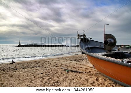 Fishing Boats Stranded On Aguda Beach And Giant Waves Breaking On The Breakwater And The Lighthouse 