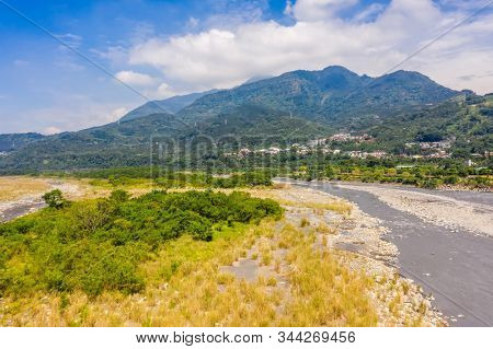 landscape of golden miscanthus with mountain and river under sky