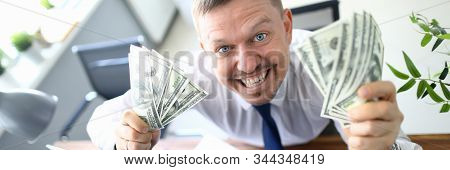 Handsome Smiling Adult Caucasian Businessman Hold Dollar Paper Cash Bancnote In Hands Against Office