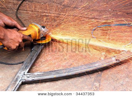 ช่างใช้ A นวดหยอด Sawing นวลขอบของแถบเหล็กรอยหยาบ