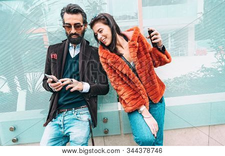 Modern Hipster Couple Having Fun Using Mobile Smart Phone Outside - Social Interaction Concept With 