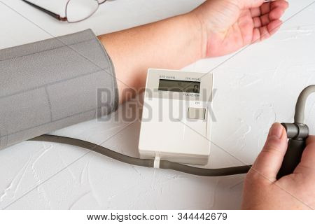 Checking Blood Pressure With Measuring Device. Healthcare And Medical Concept