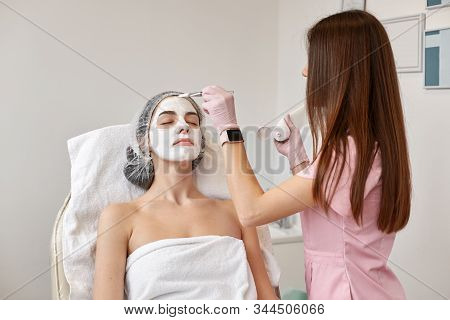 Portrait Of Beautiful Woman Laying Wrapped White Towel On Comfortable Couch. Cosmetology Specialist 