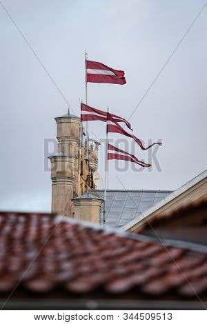 4 Latvia Latvian Flags Waving On 4 Flagpoles. Clear Blue Sky In Warm Winter Day. Photot Aken In Smal