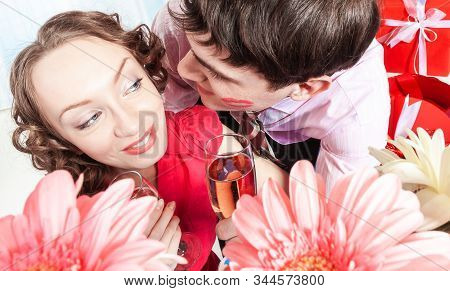 A Young Man, An Employee Of The Company Kisses His Colleague - A Young Woman With Curly Hair. The Ma