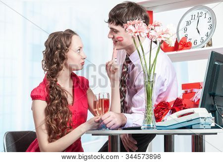 A Young Man, An Employee Of The Company Shows Courtship To His Colleague Young Woman With Curly Hair