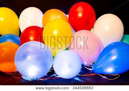 Colorful Balloons Illuminated With Intern Led Light Against A Dark Background