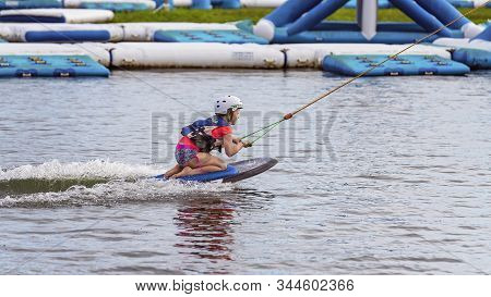 Mackay, Queensland, Australia - January 2020: A Child Wearing A Safety Helmet And Life Jacket Enjoyi