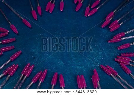 Set Of Various Mascara Brushes With Mascara Strokes On Black Background. Top Views Clear Space