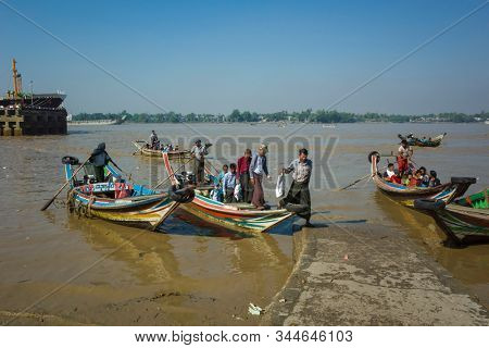 Yangon, Myanmar - December 27, 2019: Yangon River. Wooden boats - traditional public transport for crossing river