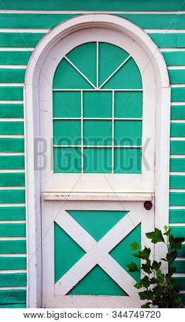 Arched Door Has White Trim And Is Painted Bright Turquoise.