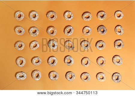 Bublik Cookies Pattern. Ring Shaped Roll Cookies On Orange Background.