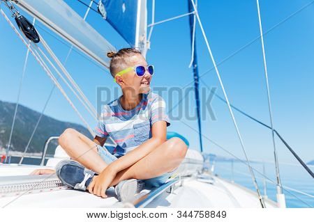 Little Boy On Board Of Sailing Yacht On Summer Cruise. Travel Adventure, Yachting With Child On Fami