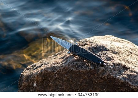 Knife Handle With Cullet. Knife On The Background Of The River.