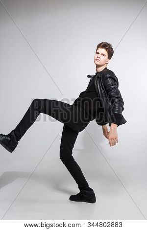 Caucasian Young Guy Posing In Studio, Full-length Portrait Of A Model In Black Clothes. Handsome Tee