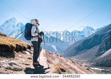 Young Hiker Backpacker Female Taking A Walking With Trekking Poles During High Altitude Everest Base