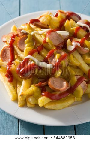 Typical Latin America Salchipapa On Blue Wooden Table. Sausages With Fries, Ketchup,mayo And Mustard
