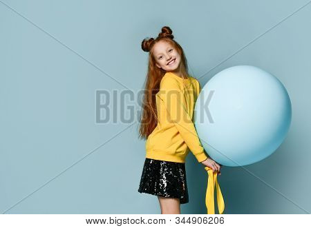 Red-headed Teenage Girl With Fancy Hairstyle In Yellow Sweatshirt, Black Skirt, . She Holding Balloo