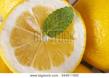 Lemon Slice With Mint Leaf Close Up. Detail View Of Juicy Lemon With Mint. Vitamin C Concept.