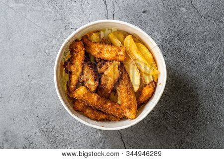 Take Away Fish And Chips Made With Breaded And Fried Seabass In Plastic Box Package / Container.