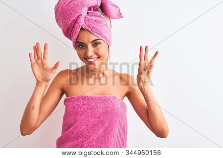 Young beautiful woman wearing shower towel after bath over isolated white background showing and pointing up with fingers number eight while smiling confident and happy.