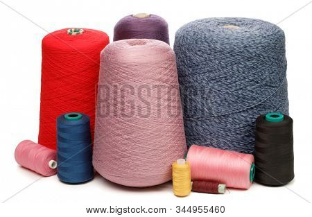 Cones and spools of synthetic or cotton threads on white background. Spool of yarn using for weaving in textile manufacturing
