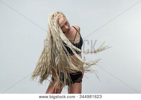 A Girl With African Hairdo Pigtails Dread With A Technique Of Zizi, Moves Dancing On A Light Backgro