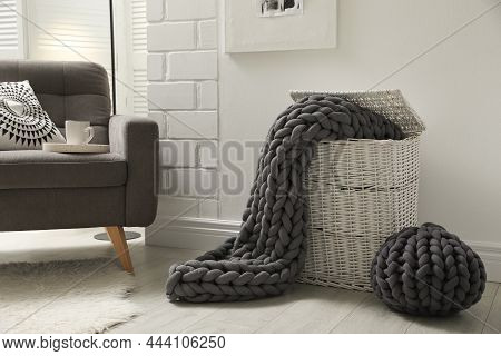 Living Room Interior With Armchair, Pouf And Chunky Knit Blanket