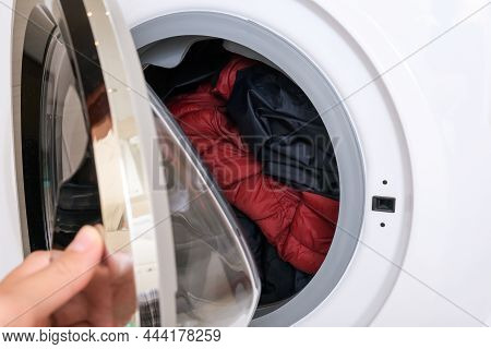 A Hand Clothing A Drum Of A Washing Machine After Loading Dirty Clothes, Laundry Concept
