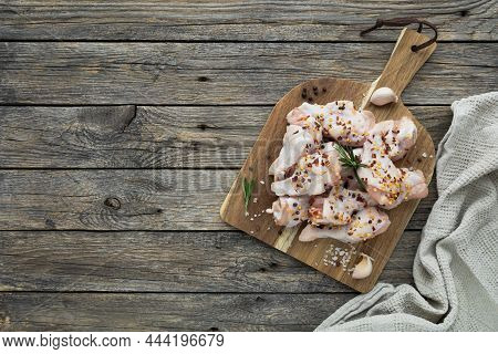 Raw Chicken Wings On Cutting Board With Ingredients For Cooking On Wood Background. Fresh Uncooked D