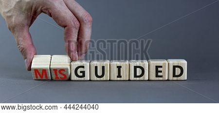 Guided Or Misguided Symbol. Businessman Turns Wooden Cubes And Changes The Word Misguided To Guided.