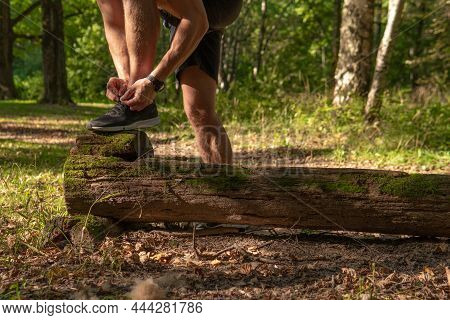 The Sportsman Is Tying The Laces Of His Legs In Sneakers Close Up The Athlete Runs In The Park Outdo