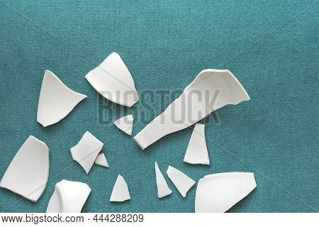Splinters And Fragments Of The Broken White Ware. Metaphor Of A Family Quarrel. Broken Plate, Glass.