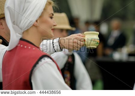 Braila, Romania - August 26, 2021: Men And Women Dressed In Romanian Traditional Costumes Perform A 