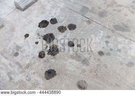 Engine Oil Leakage On Concrete Floor. Black Engine Oil On Concrete Floor. Engine Oil Leak From The E